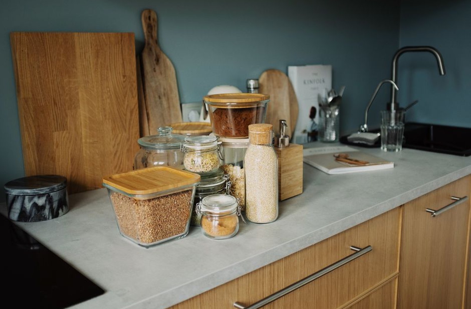 Glass jars of grains and dry pantry staples arranged on a kitchen counter.